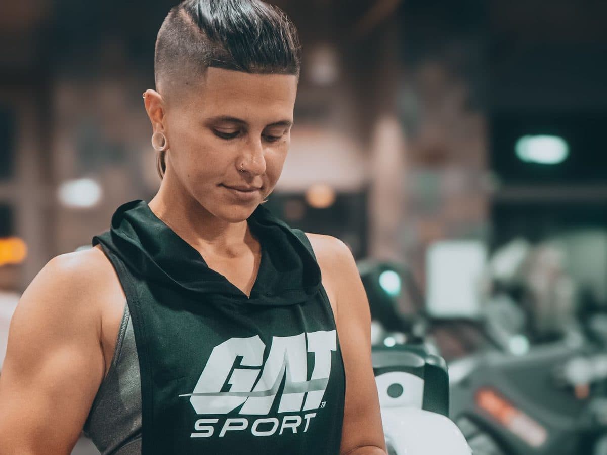Gym member checking their phone in the gym, using their martial arts club’s branded member app